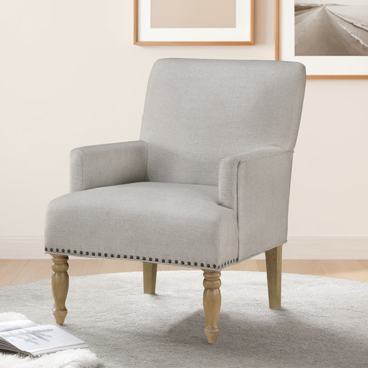Light grey fabric armchair with studded trim and turned wooden legs perfect accent chair