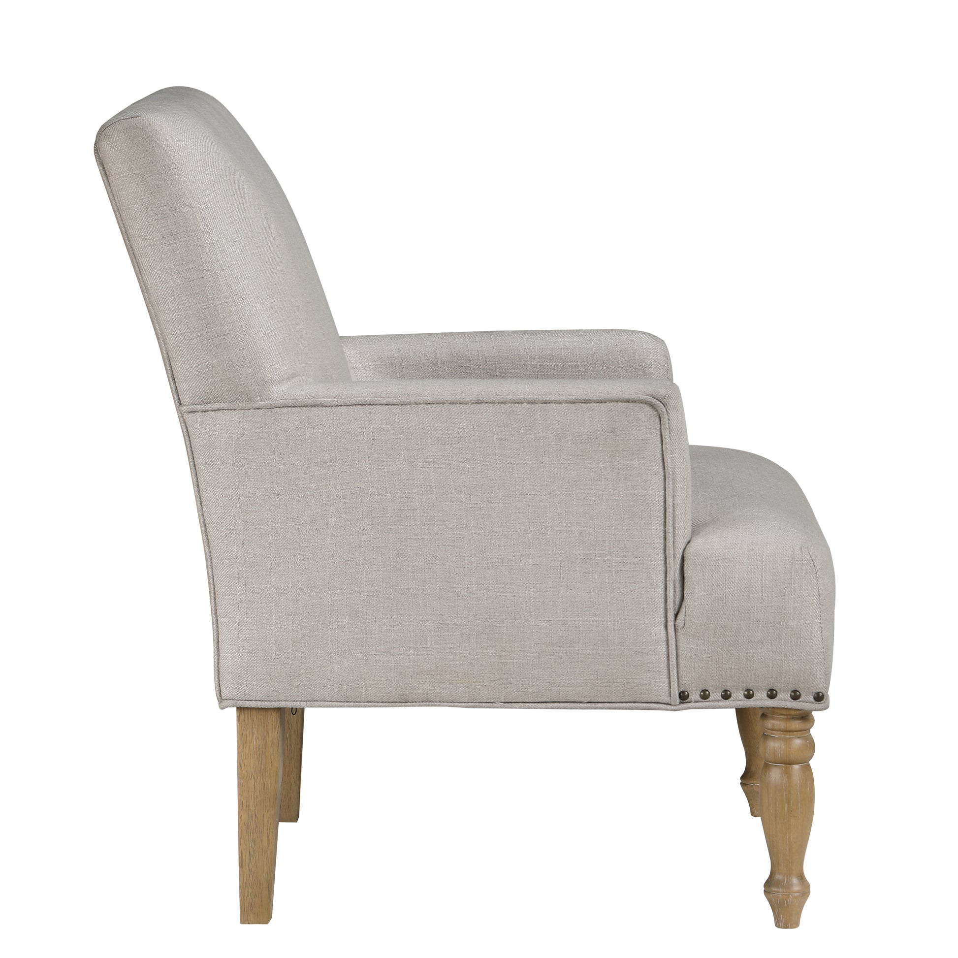 Light grey upholstered armchair with carved wooden legs and antique brass nailhead trim