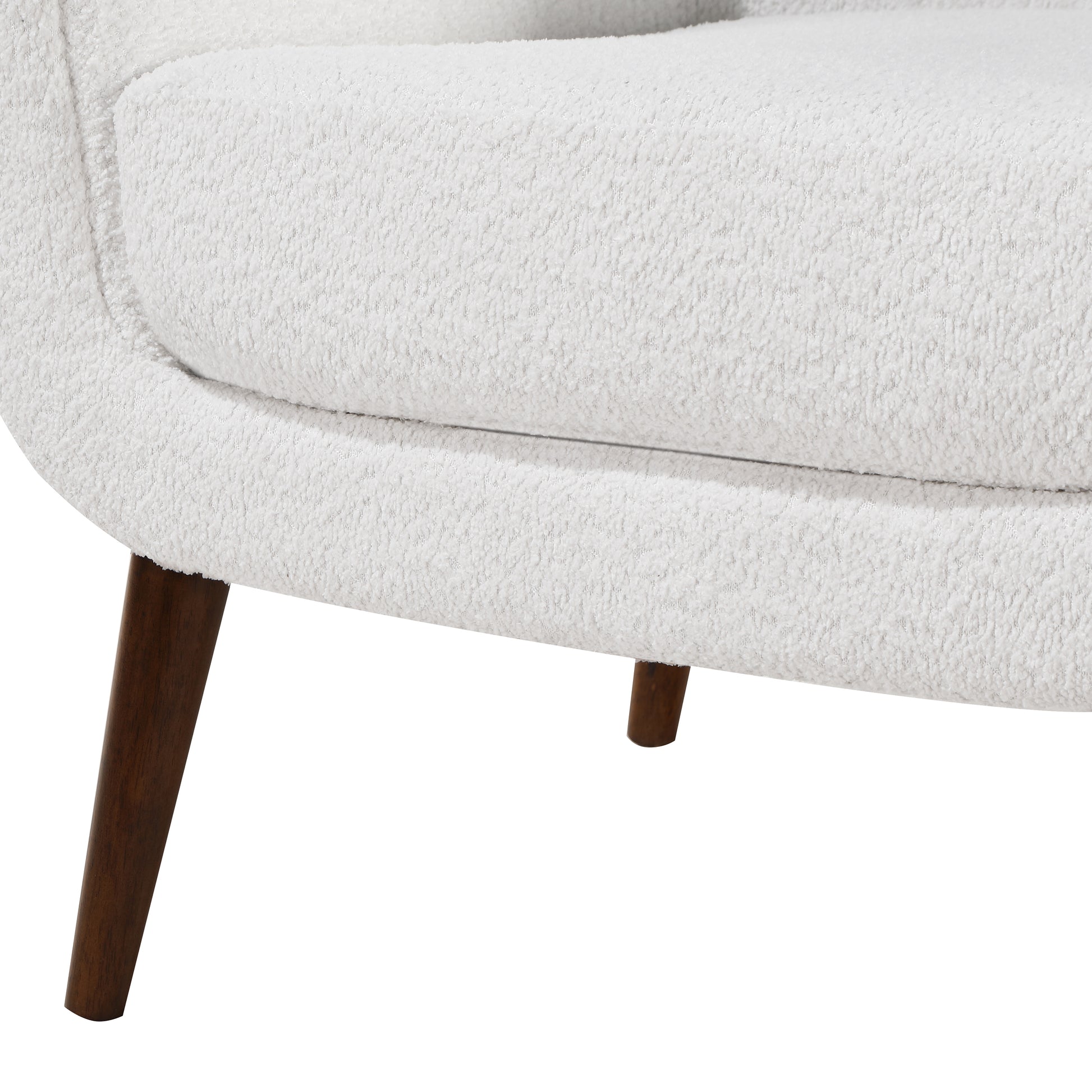 White boucle armchair detail with tapered wooden legs offering a cozy modern aesthetic