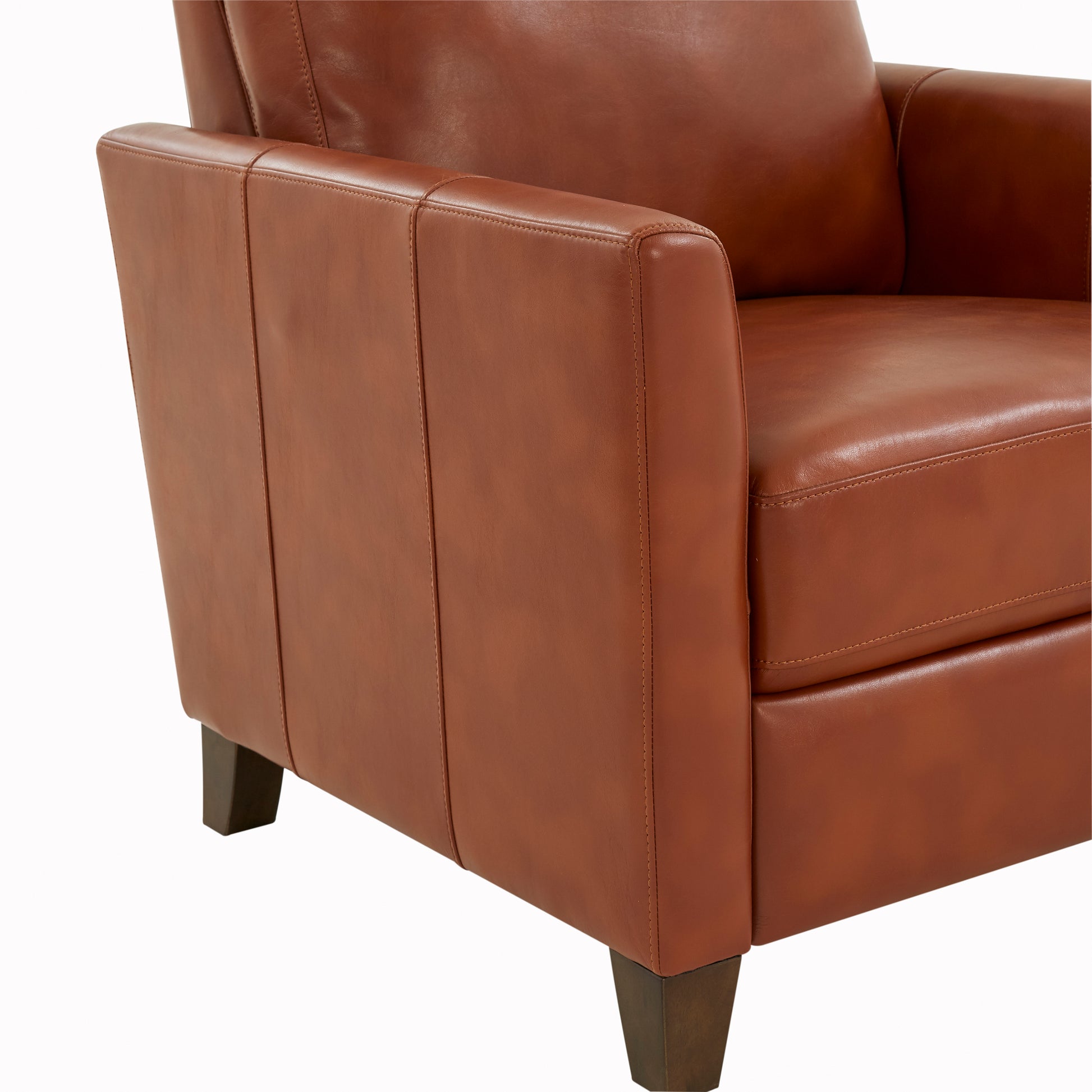 Closeup of a warm brown leather armchair armrest with visible stitching details