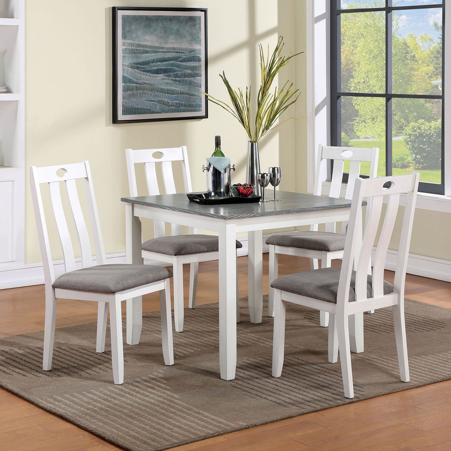 White wooden dining chairs with grey upholstered seats around a grey and white dining table