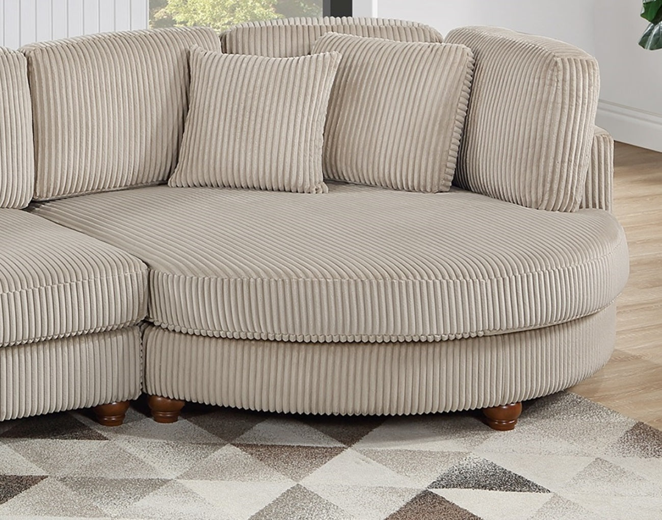 Curved sectional sofa in beige corduroy fabric with plush cushions and dark wooden legs