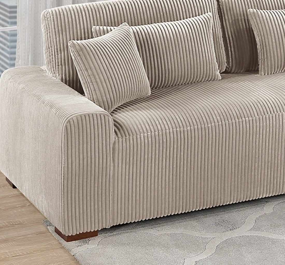 Beige corduroy sofa with plush throw pillows perfect for a cozy living room setup