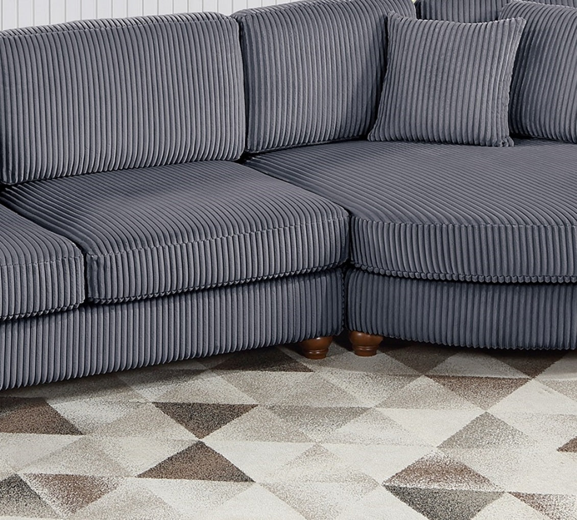 Closeup of a dark gray corduroy sectional sofa with plush cushions