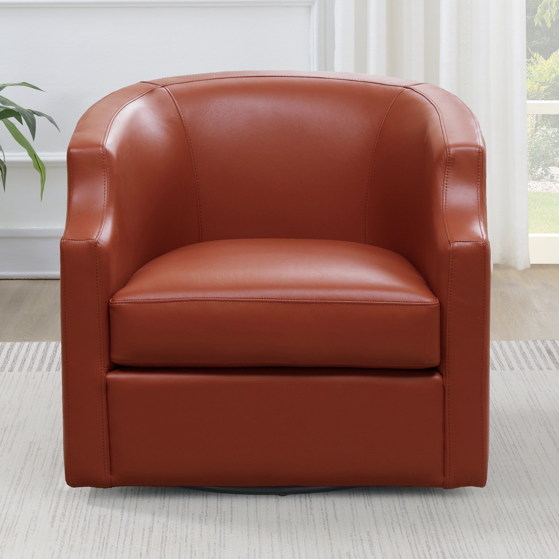 Swivel accent chair upholstered in rich cognac leather featuring plush cushioning and a contemporary barrel design