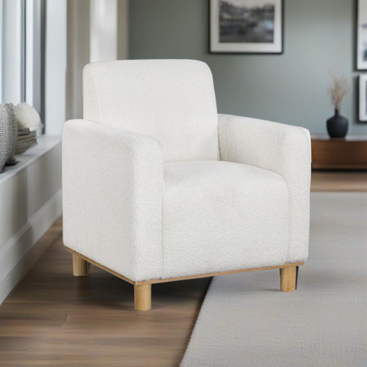 Plush white boucle armchair with natural wood legs perfect for a cozy living room