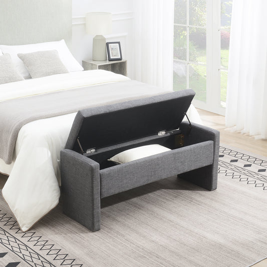 Grey upholstered storage bench with lid open revealing storage space