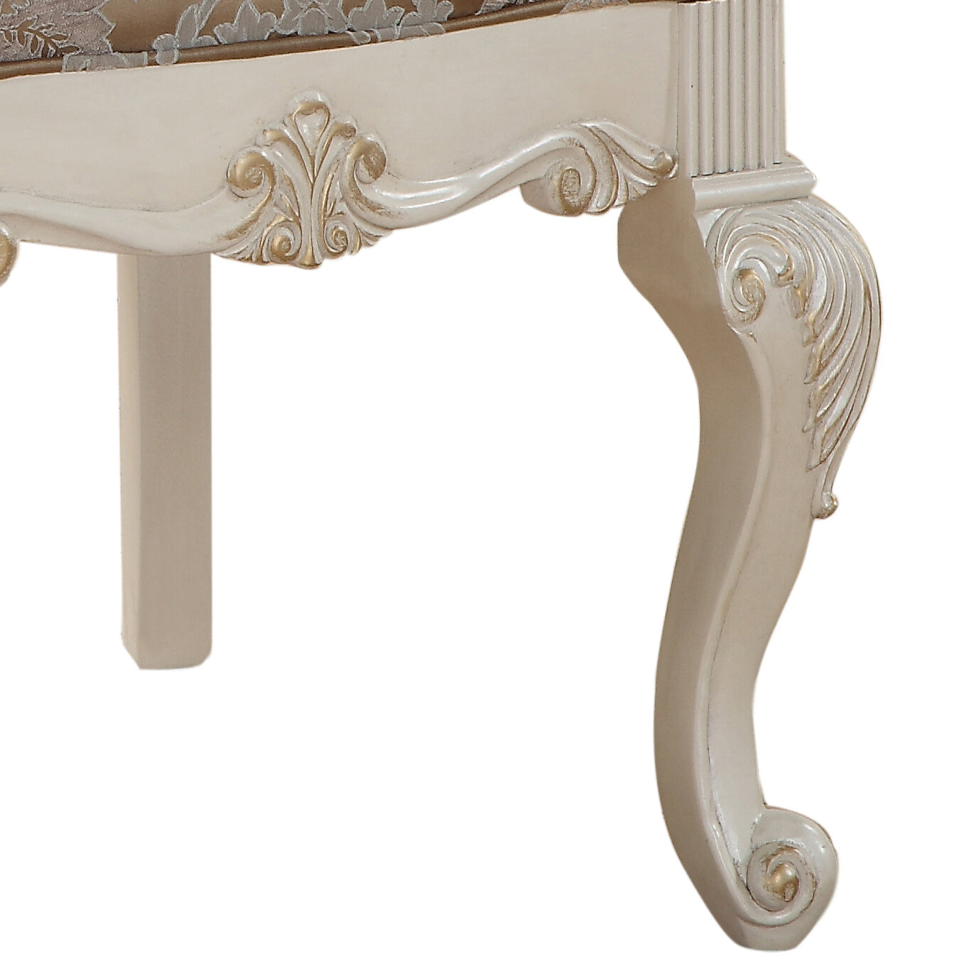 Ornate carved ivory wooden leg with gold accents on a classic armchair