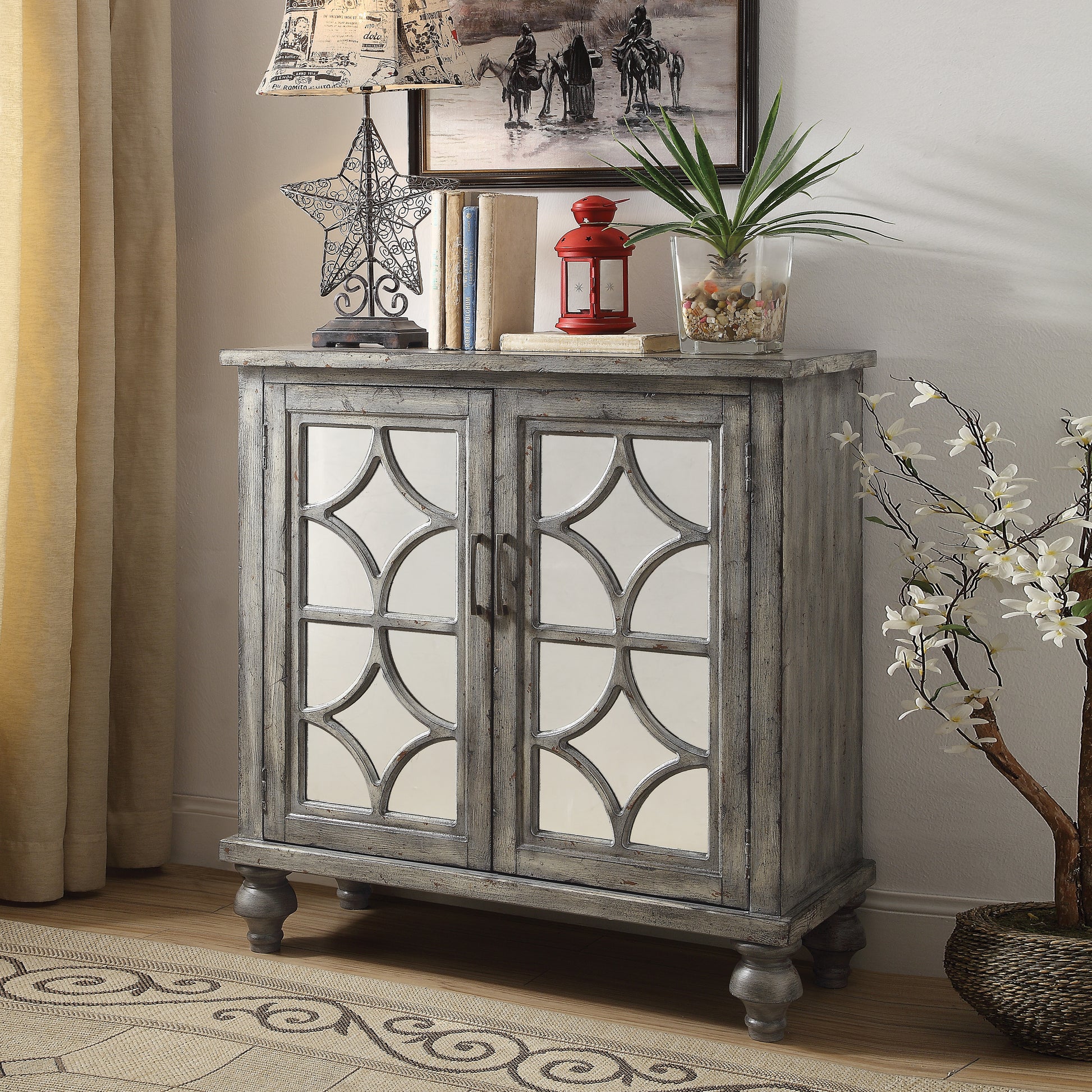 Distressed gray accent cabinet with mirrored geometric doors and decorative legs