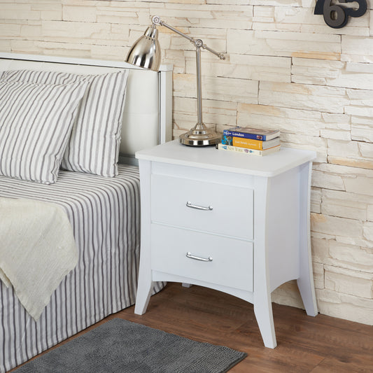 White wooden bedside table with two drawers and silver handles beside a bed