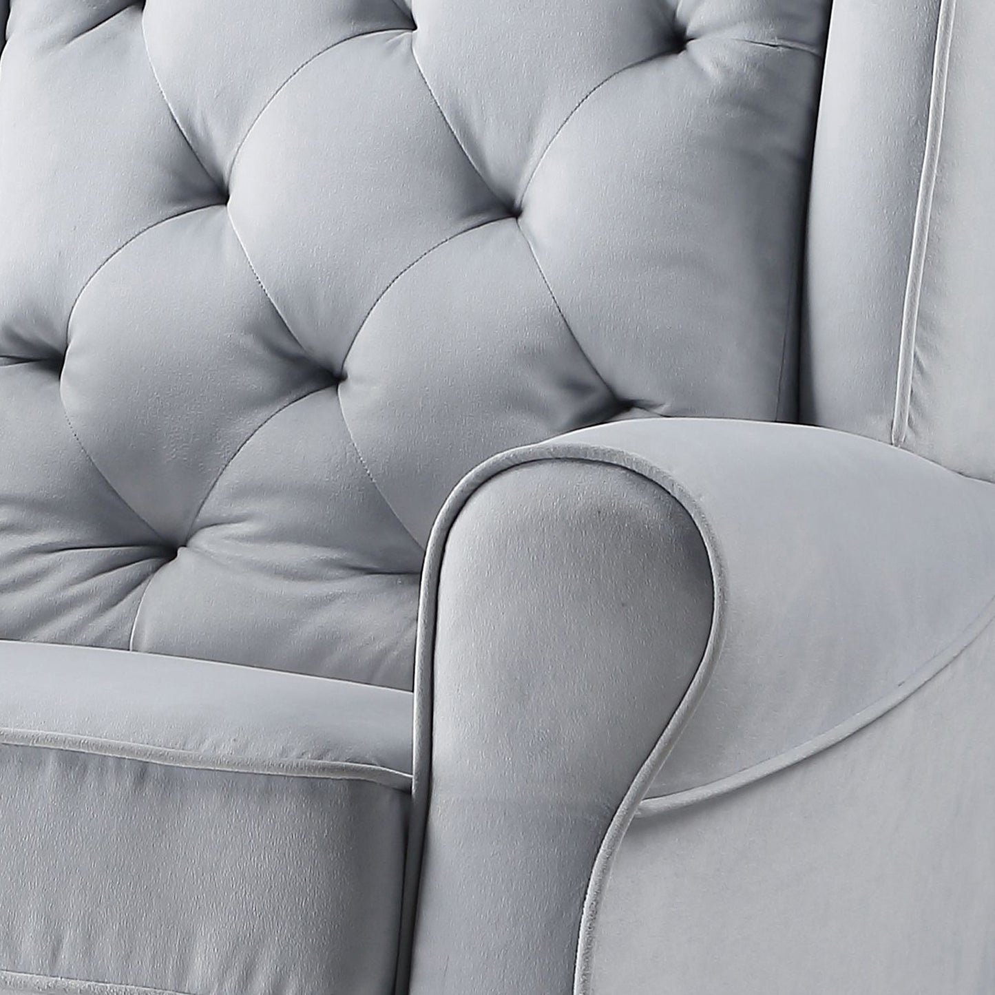 Grey velvet armchair with elegant button tufting on the back and smooth armrest