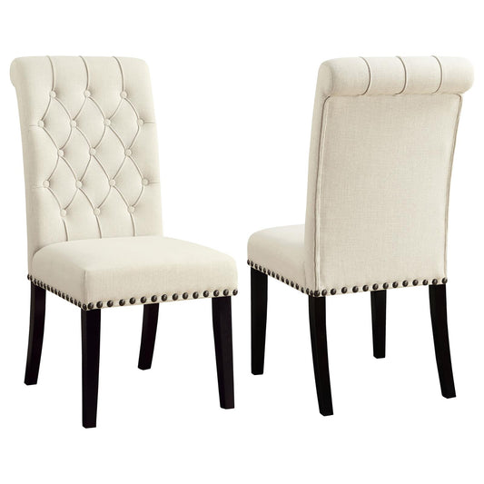 Tufted cream fabric dining chair with dark wood legs and decorative nailhead trim