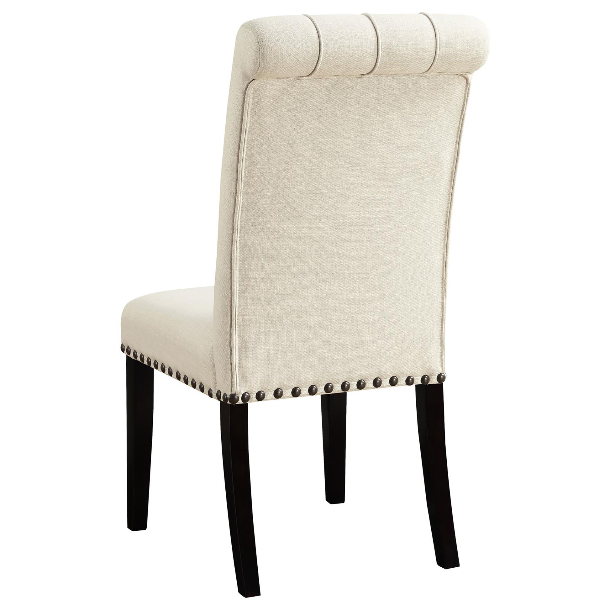 Cream upholstered dining chair with button tufting and dark wood legs