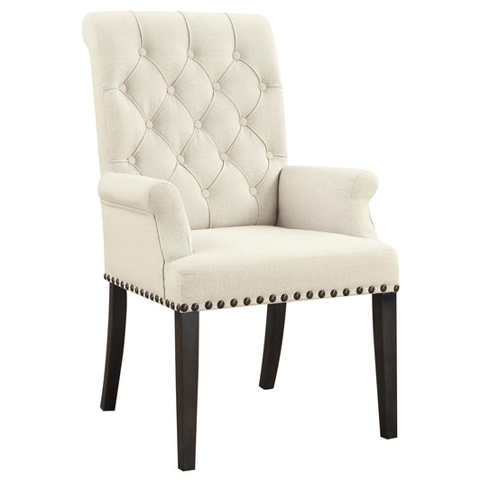 Cream tufted accent chair with dark wood legs and nailhead trim