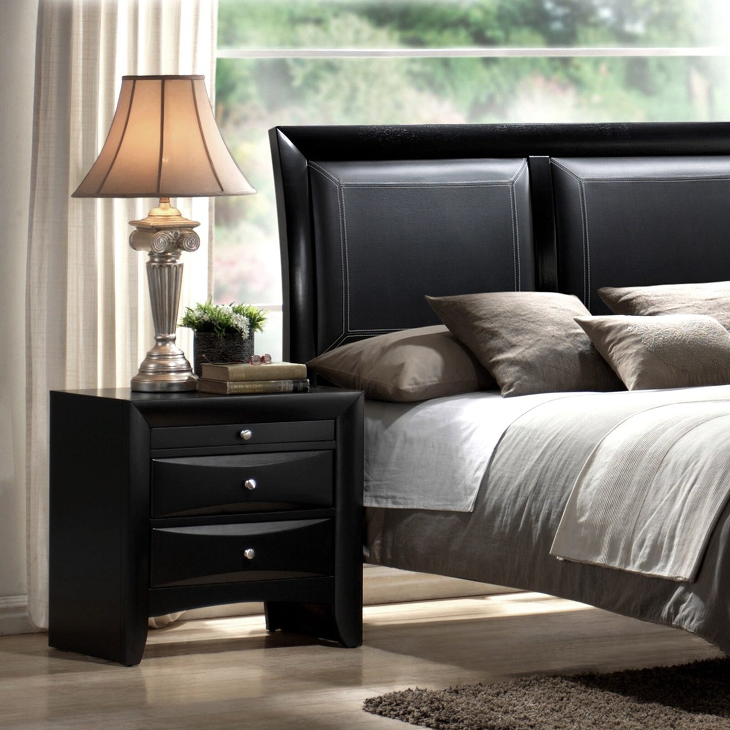 Black leather headboard with stitched detailing complemented by a modern nightstand