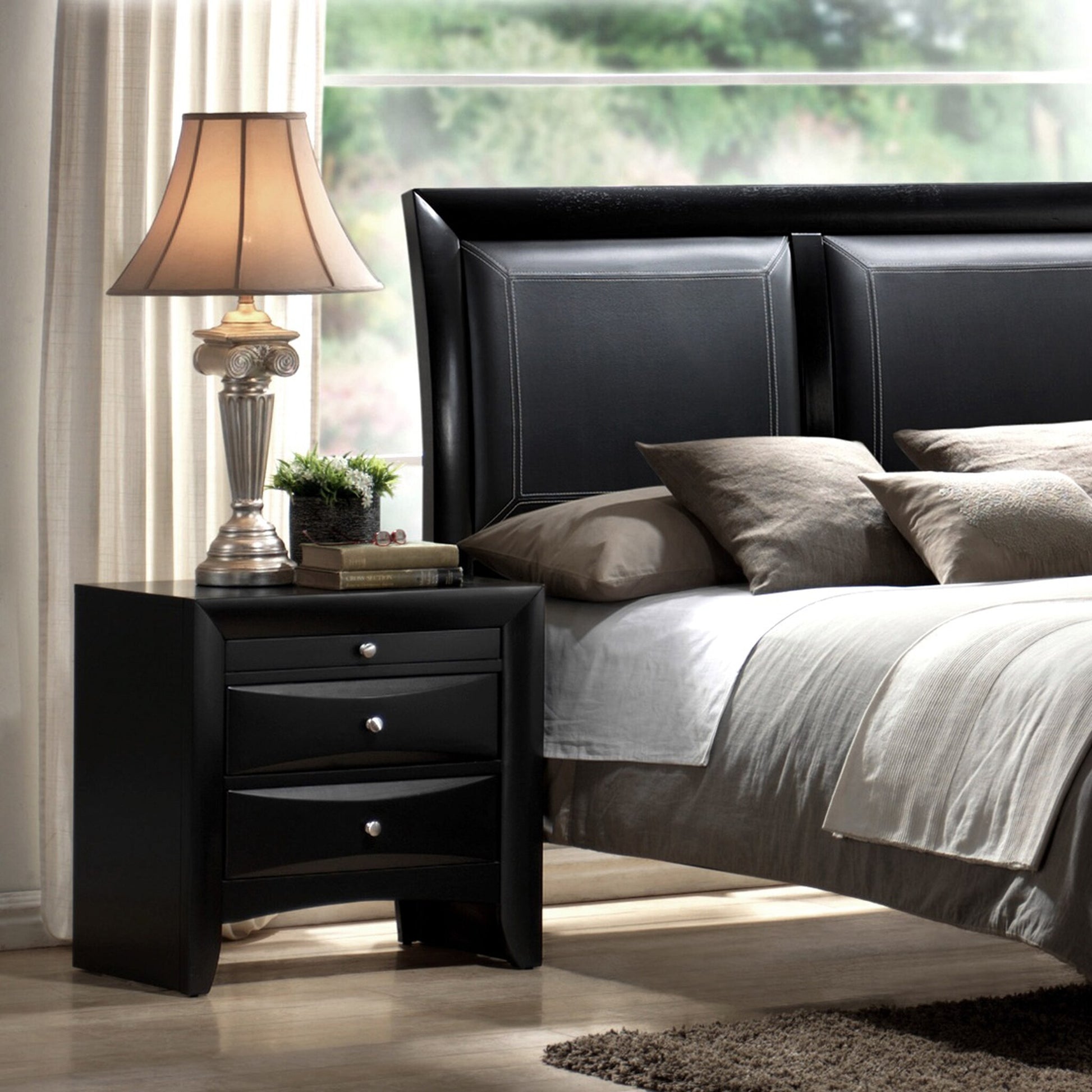 Black leather headboard with stitched detailing complemented by a modern nightstand