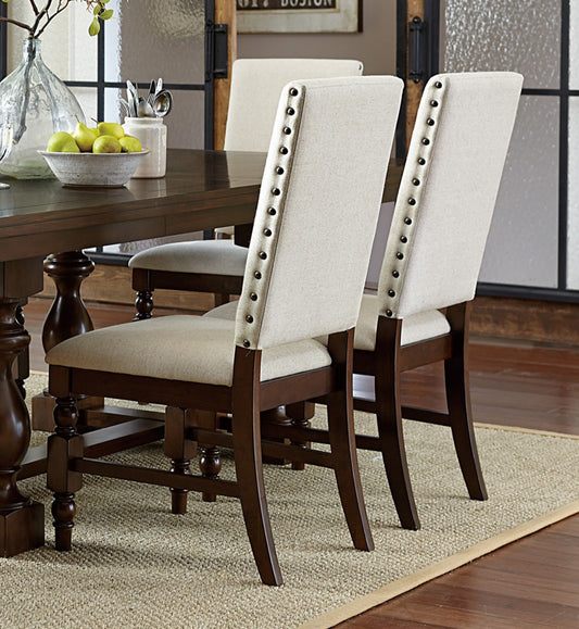 Upholstered dining chair with nailhead trim in neutral beige fabric and dark wood frame