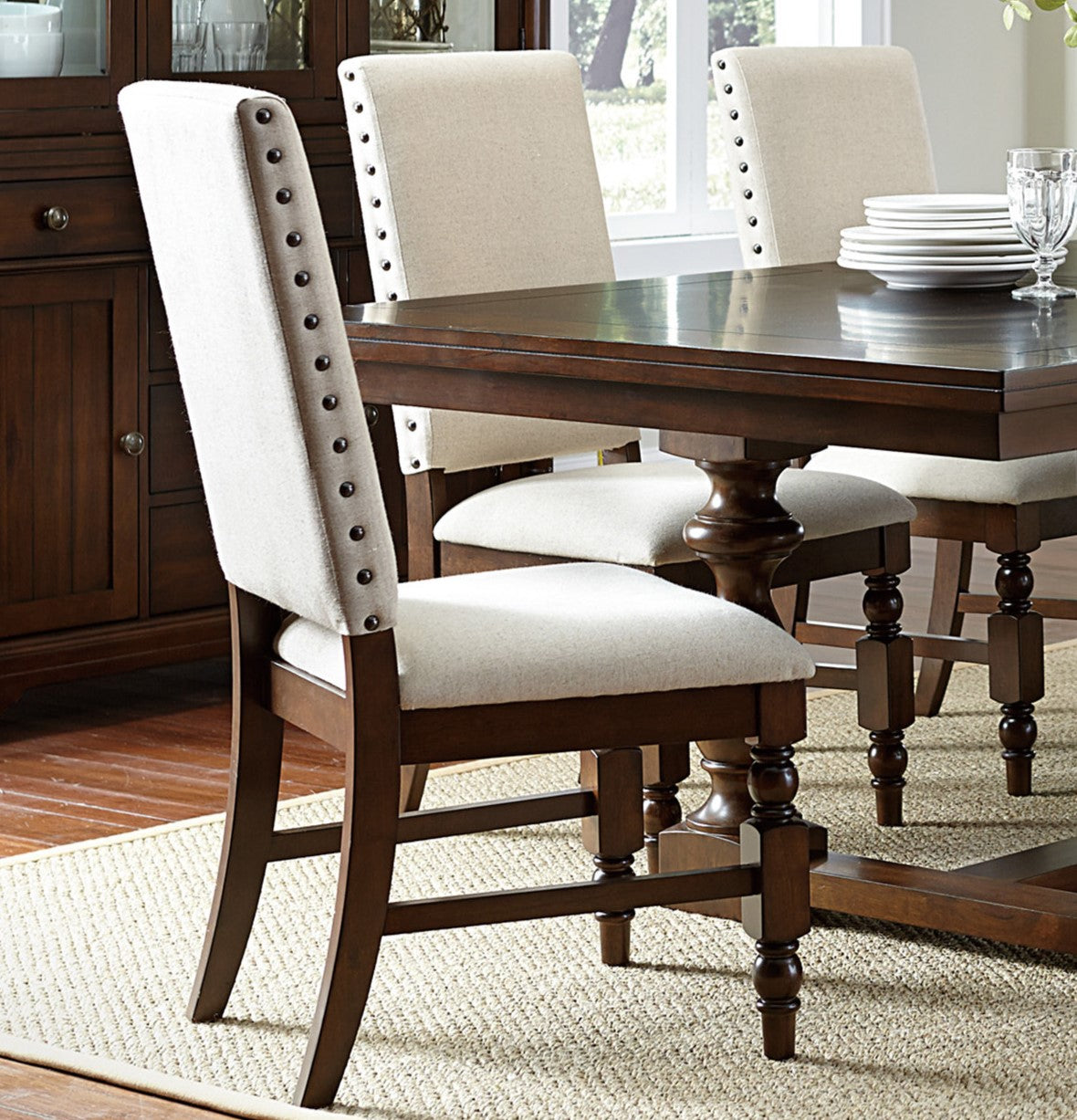 Tufted beige upholstered dining chair with dark wood legs and nailhead trim