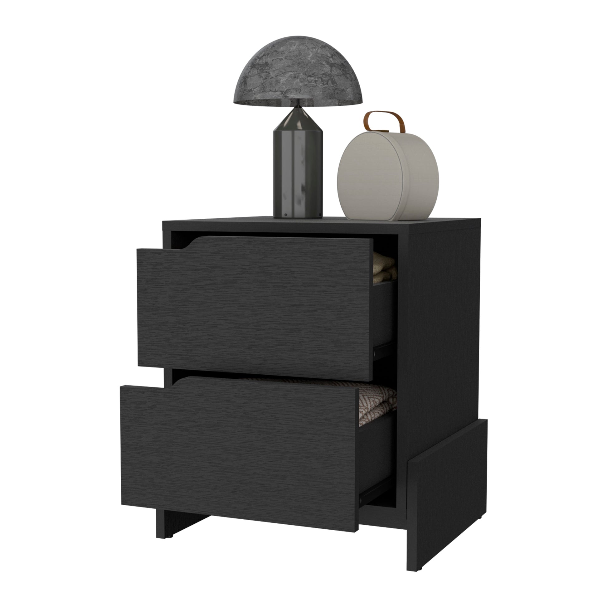 Dark wood nightstand with two open drawers displaying folded linens topped with a marbleeffect lamp and storage case