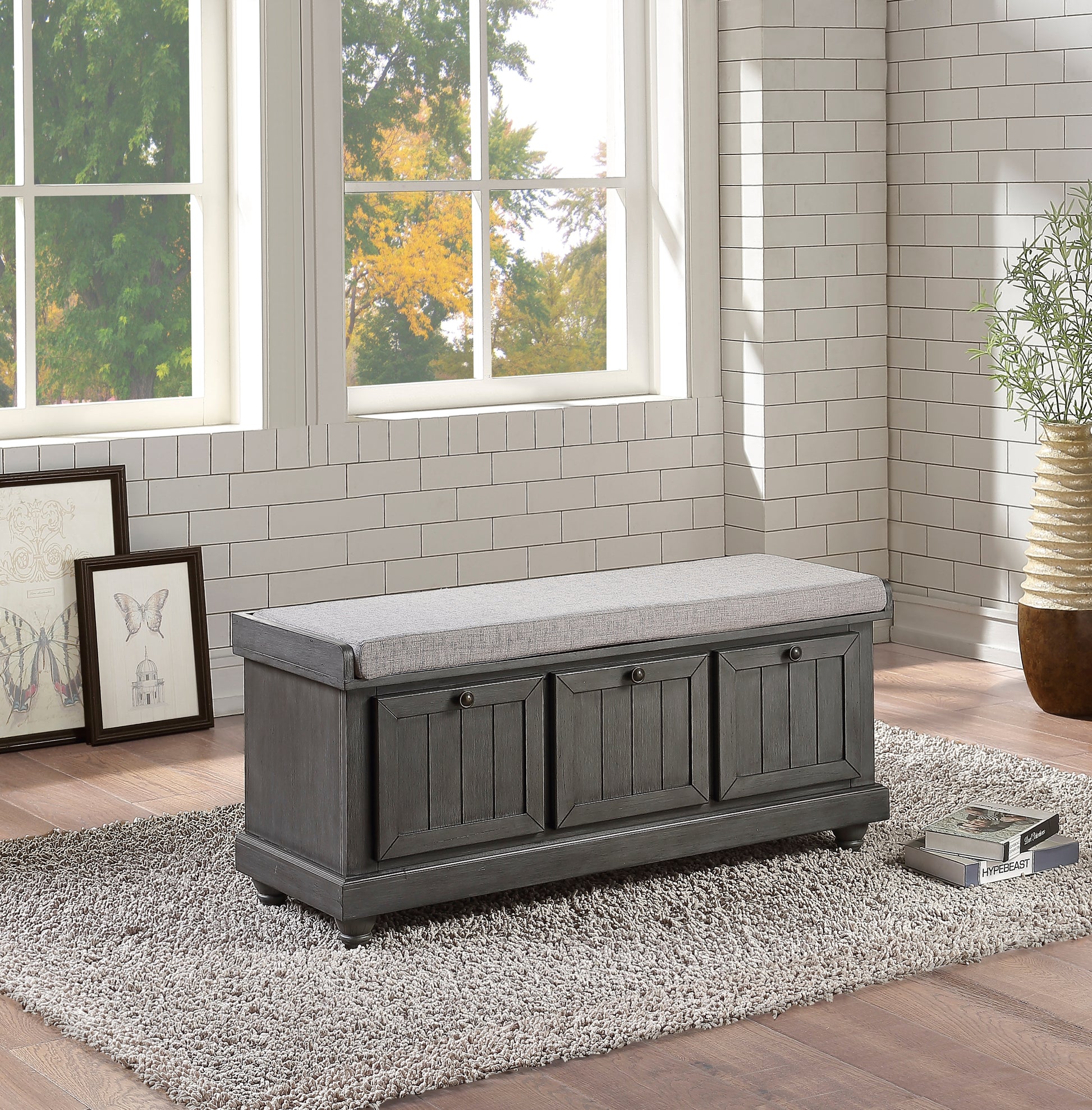 Gray wooden storage bench with upholstered seat and three cabinet doors