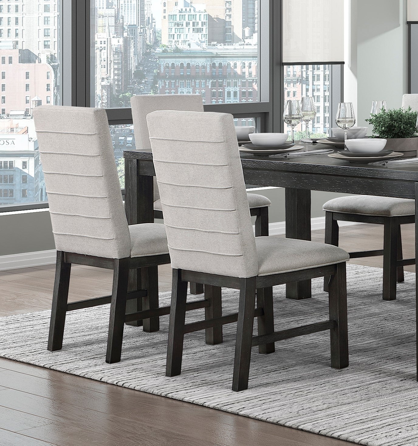 Light gray upholstered dining chairs with channel tufting on dark wood legs