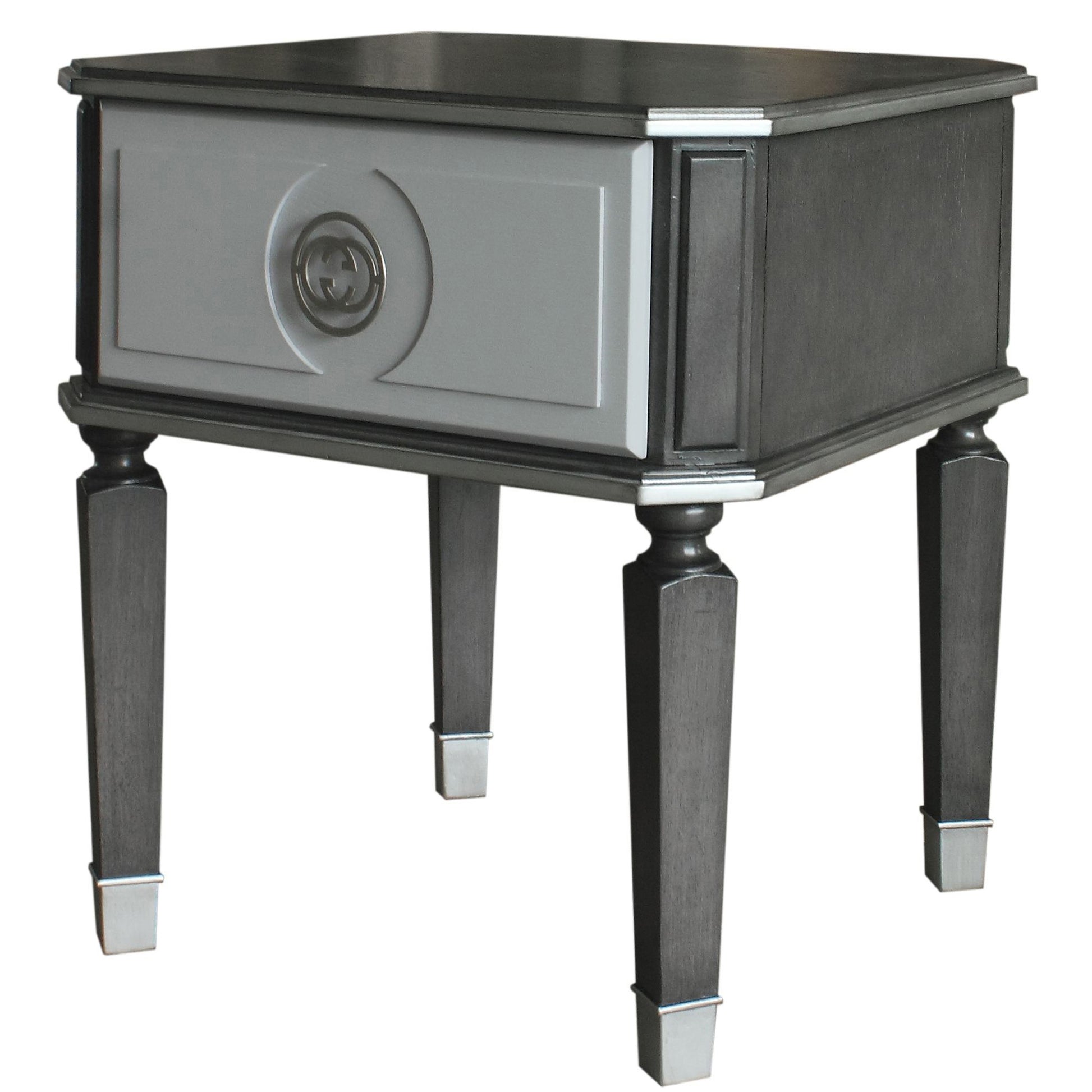 Charcoal grey wood end table with a single gray drawer featuring a silver double G logo emblem