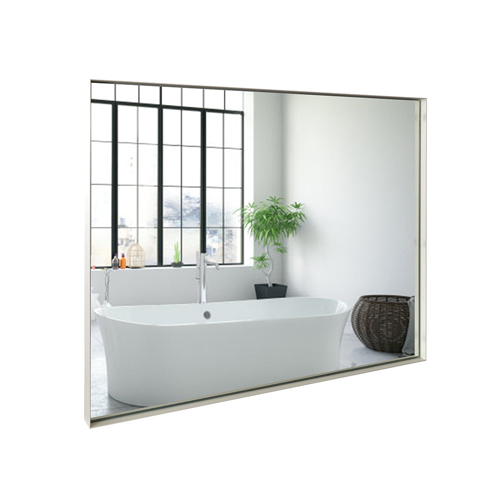 Sleek frameless bathroom mirror reflecting a modern freestanding bathtub and a large window