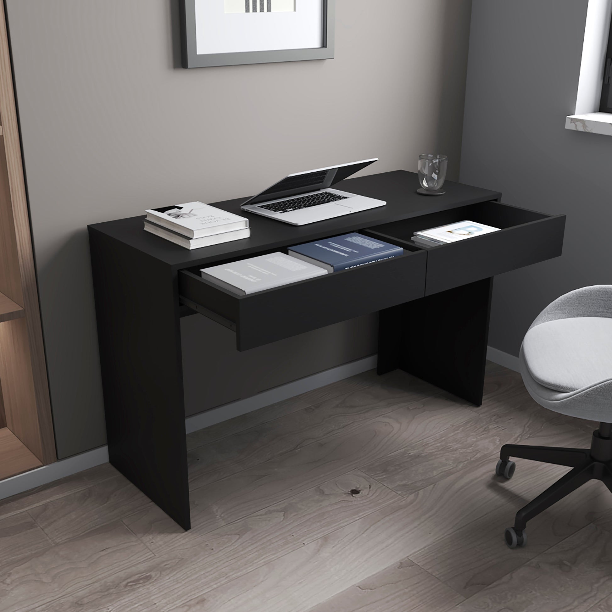 Sleek black modern desk with open drawers containing books and a laptop for a home office
