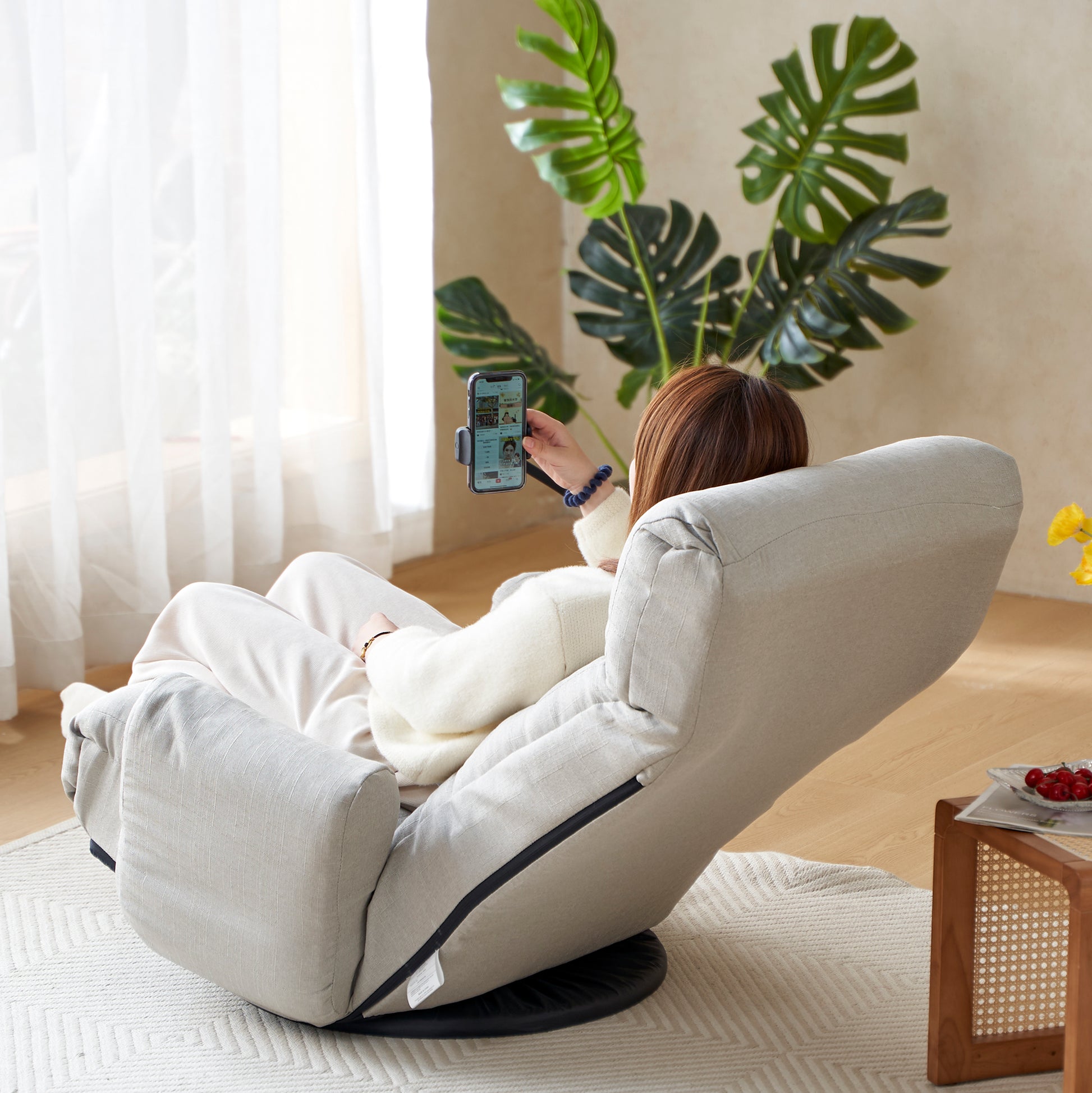 Light gray linen floor chair with adjustable back and swivel base perfect for reading