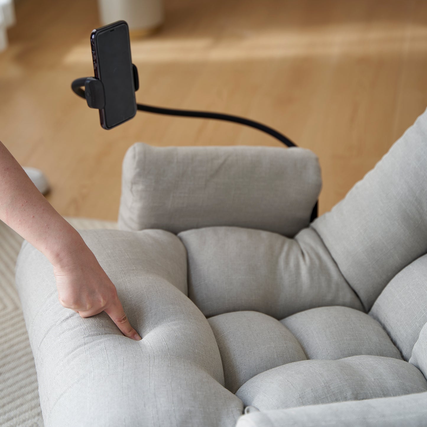 Soft gray linen floor chair with a flexible phone holder for comfortable viewing