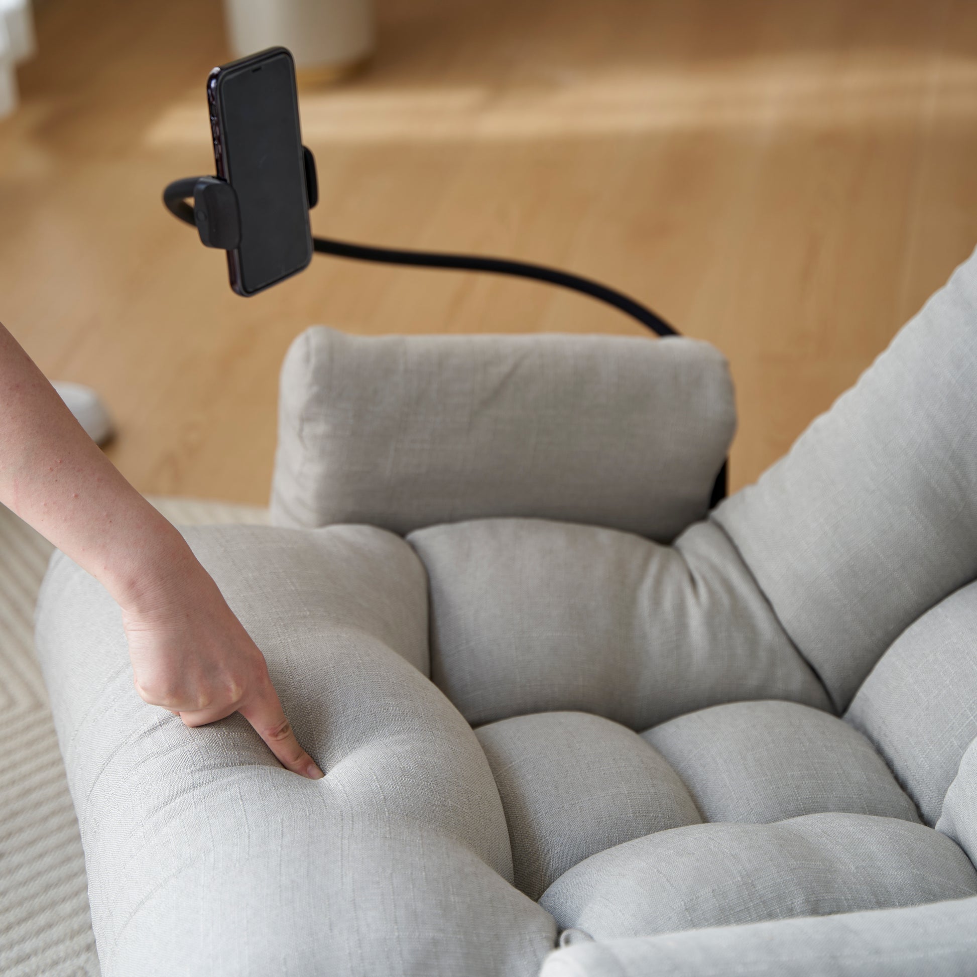 Soft gray linen floor chair with a flexible phone holder for comfortable viewing