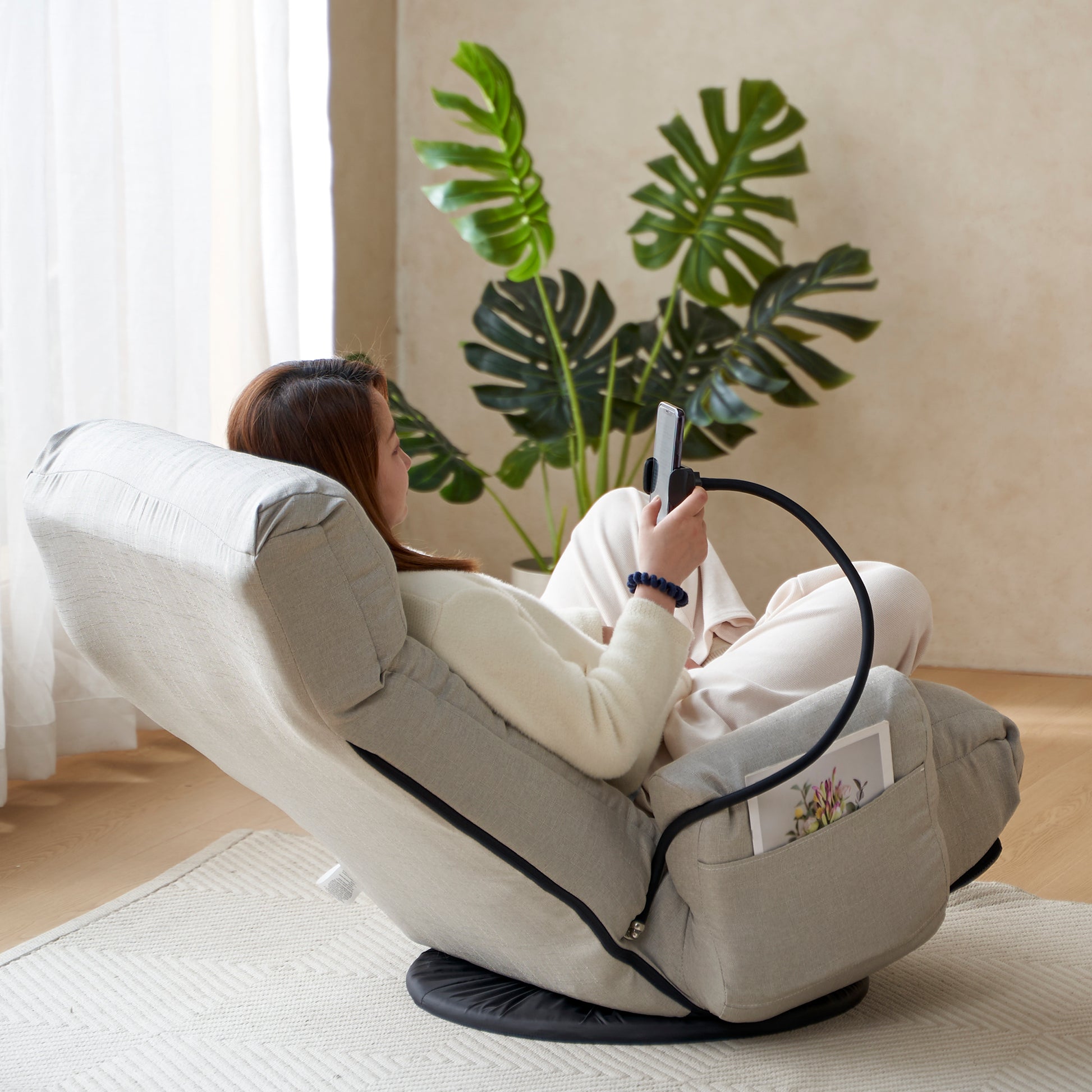 Grey reclining floor chair with a flexible phone holder perfect for reading or watching shows