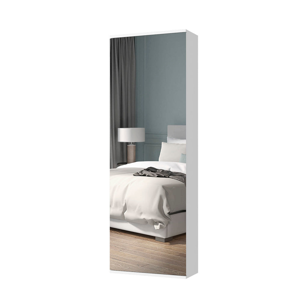 Fulllength white mirrored cabinet door reflecting a bedroom with a bed and lamp