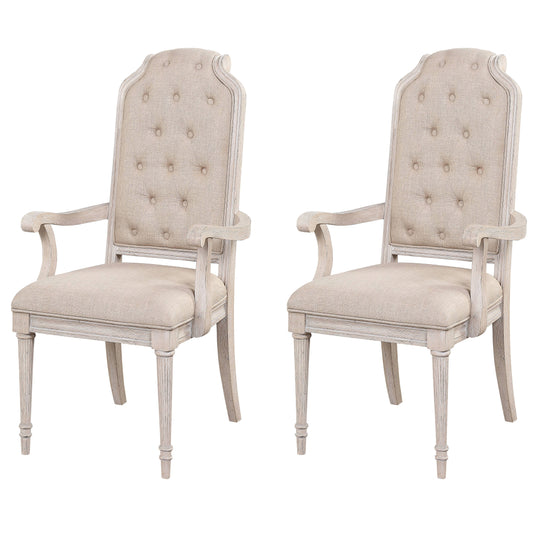 Two light beige upholstered armchairs with distressed wood frames and button tufting