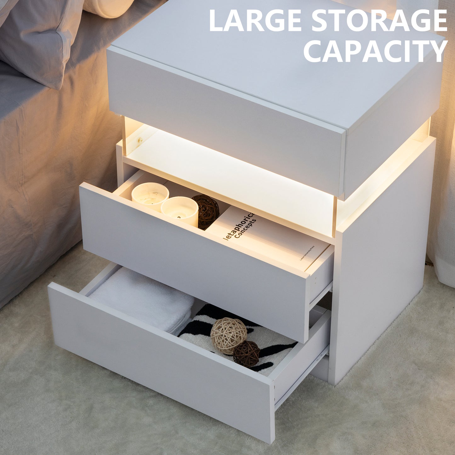 White bedside table with open drawers revealing storage