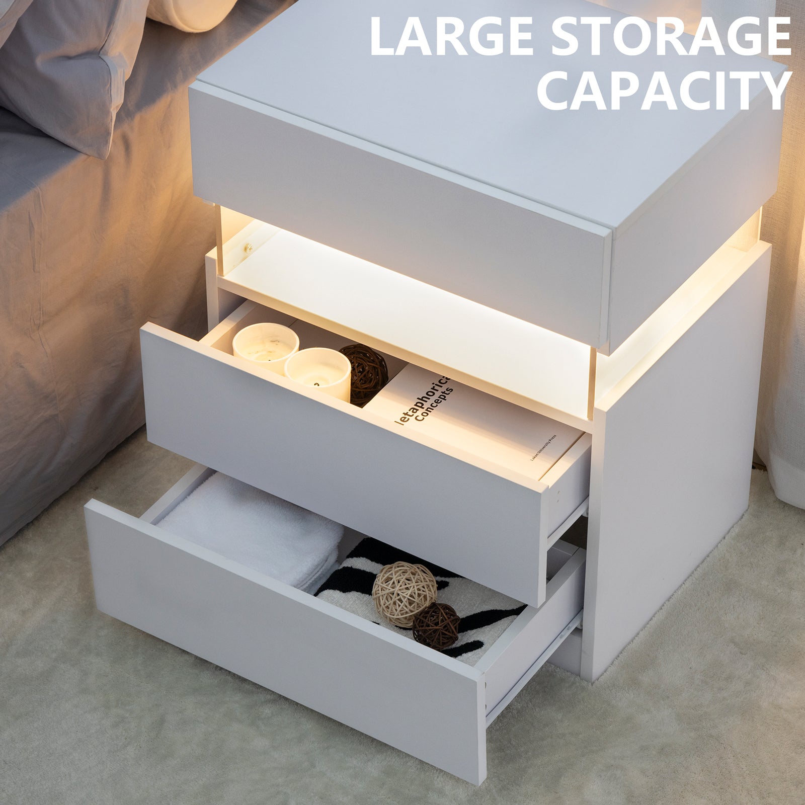 White bedside table with open drawers revealing storage