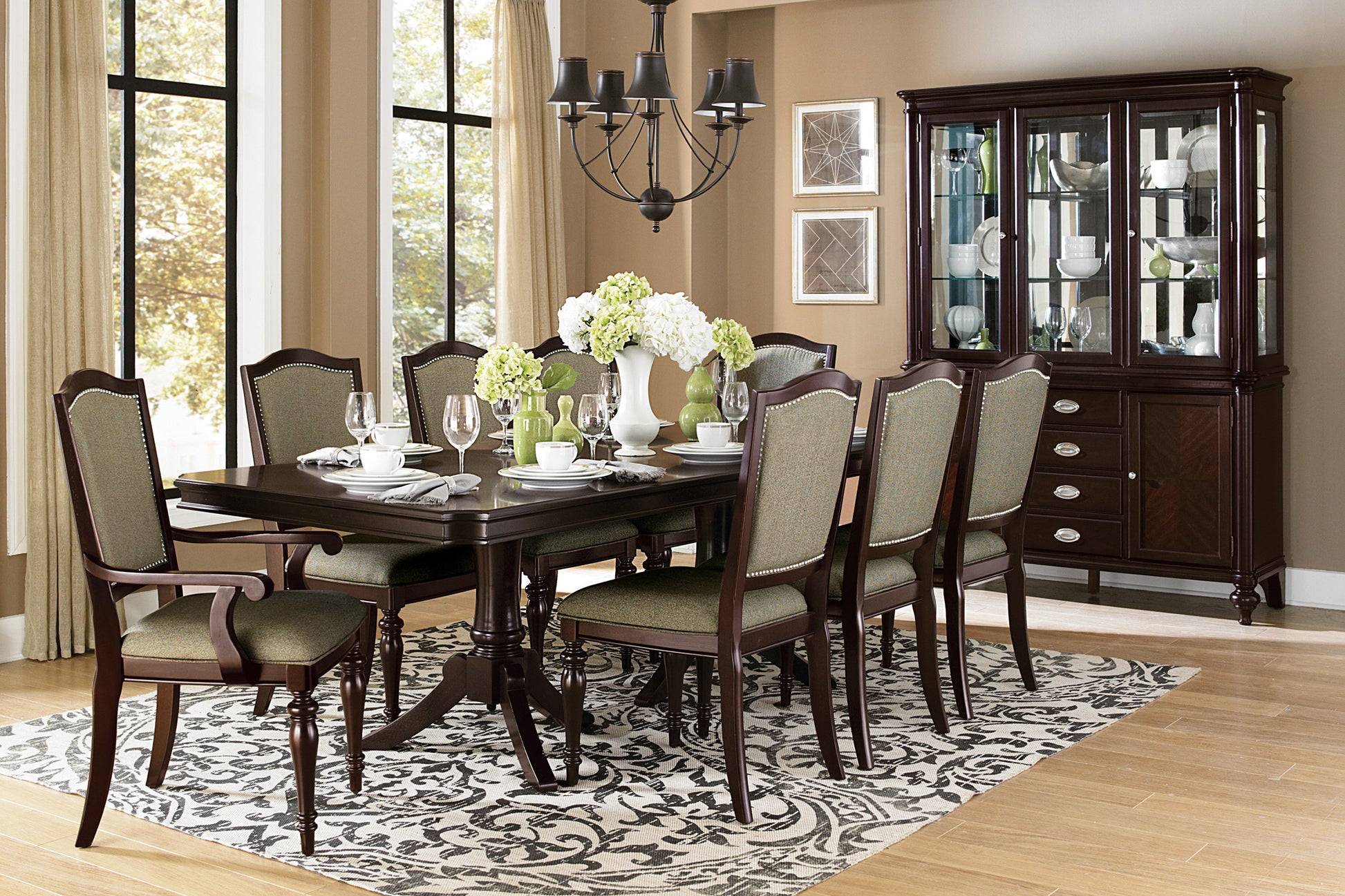 Dark wood dining table and chairs with upholstered seats and backs set for a meal