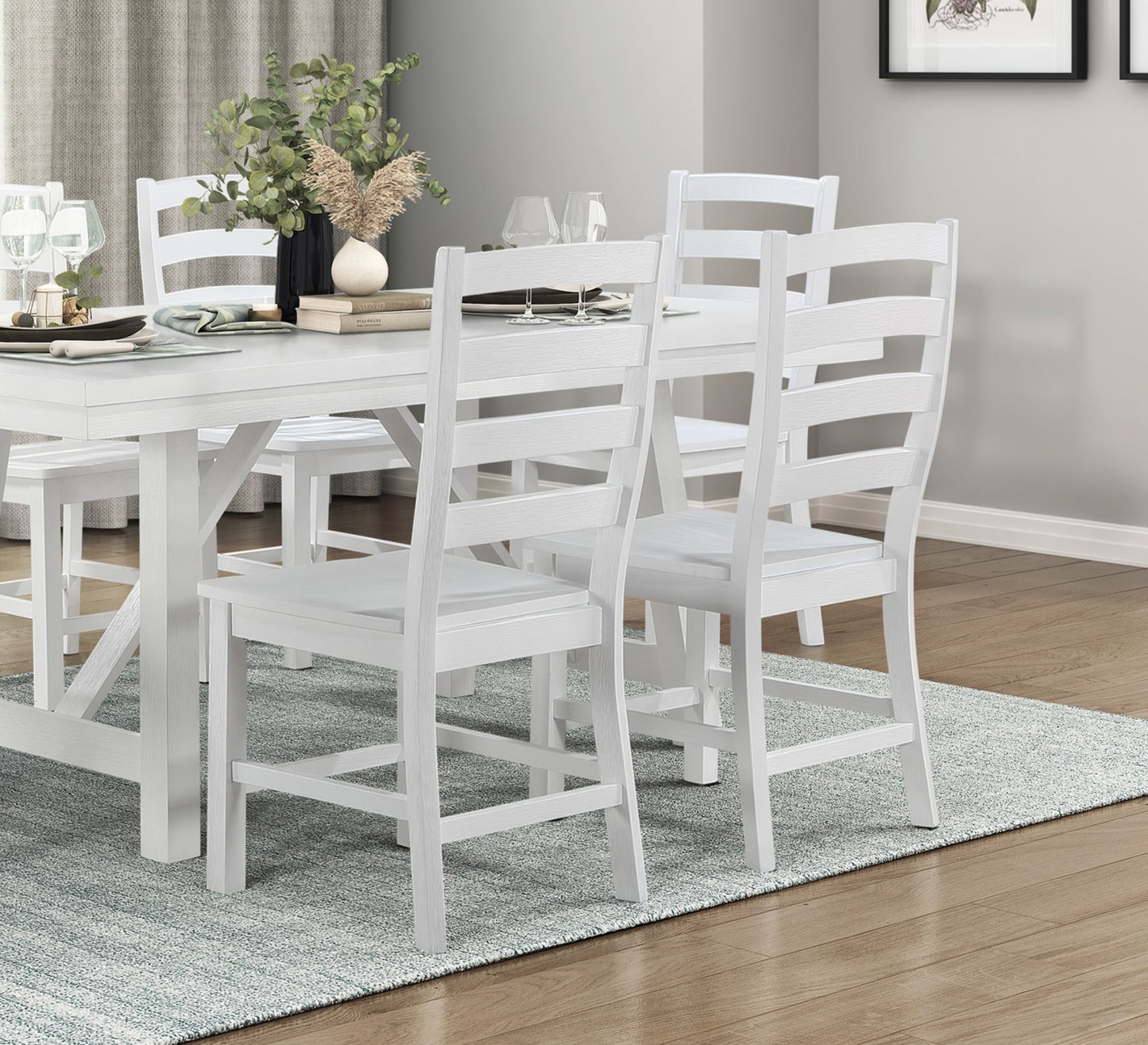 White wooden dining chairs with slatted backs and padded seats arranged around a table