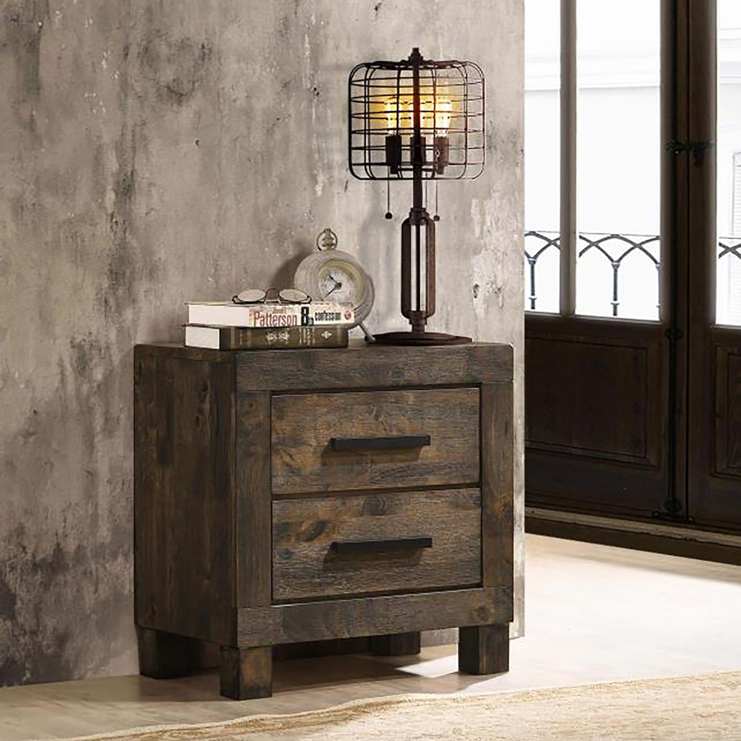 Dark wood rustic nightstand with two drawers featuring a cagestyle desk lamp and books