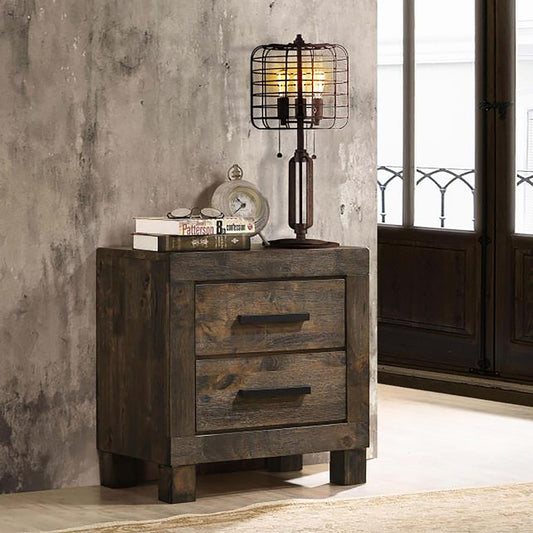Dark wood rustic nightstand with two drawers featuring a cagestyle desk lamp and books