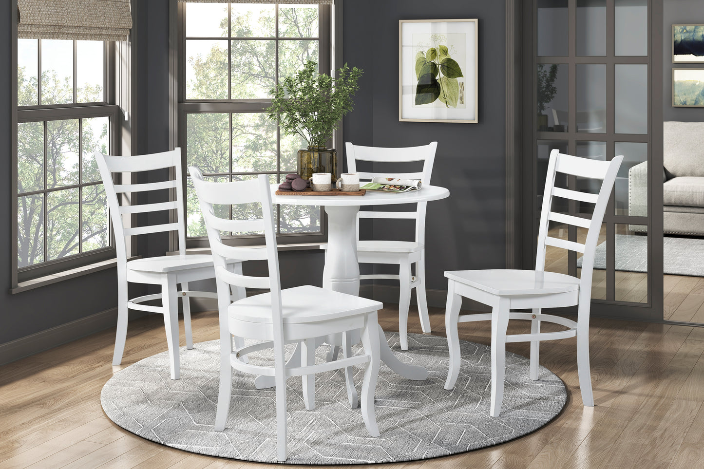 Four white ladderback chairs surround a round pedestal dining table