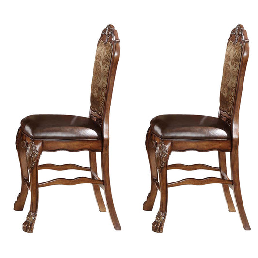 Two ornate dark brown upholstered dining chairs with carved wooden legs and patterned backs