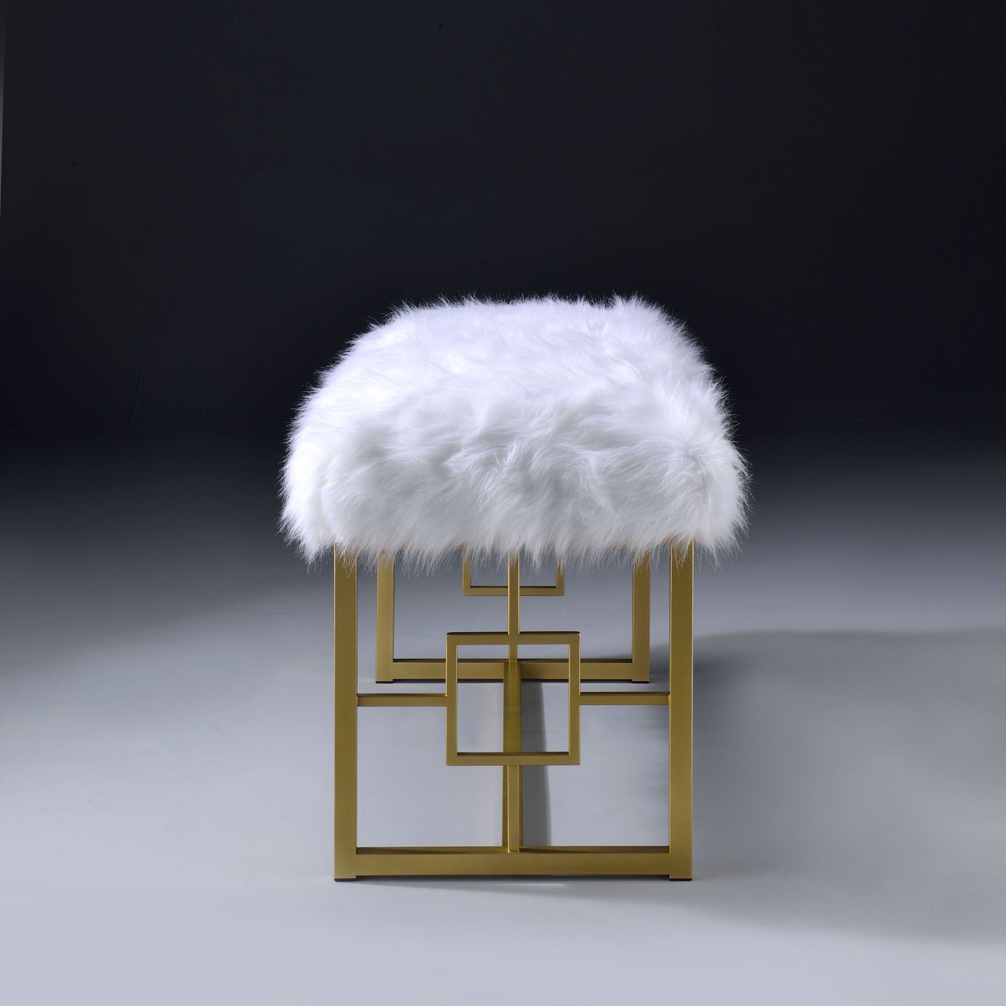 Plush white faux fur bench with gold geometric metal base and square accents