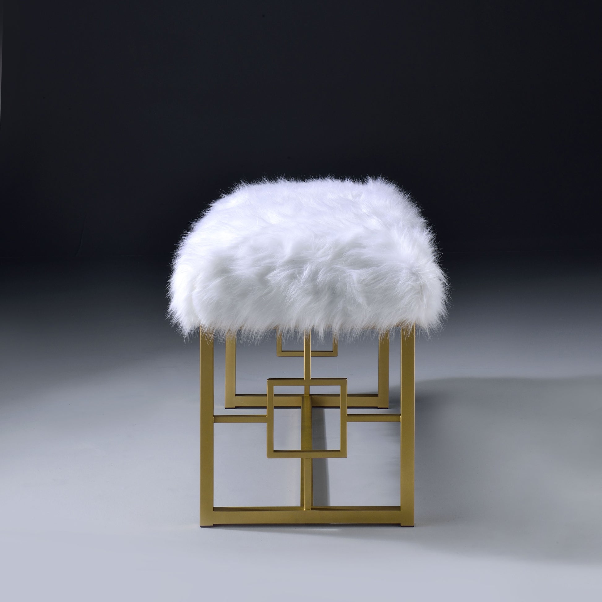 Plush white faux fur bench with gold geometric metal base and square accents