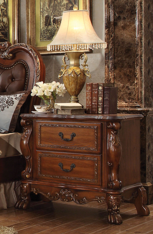 Antique mahogany nightstand with two carved drawers and ornate gold hardware