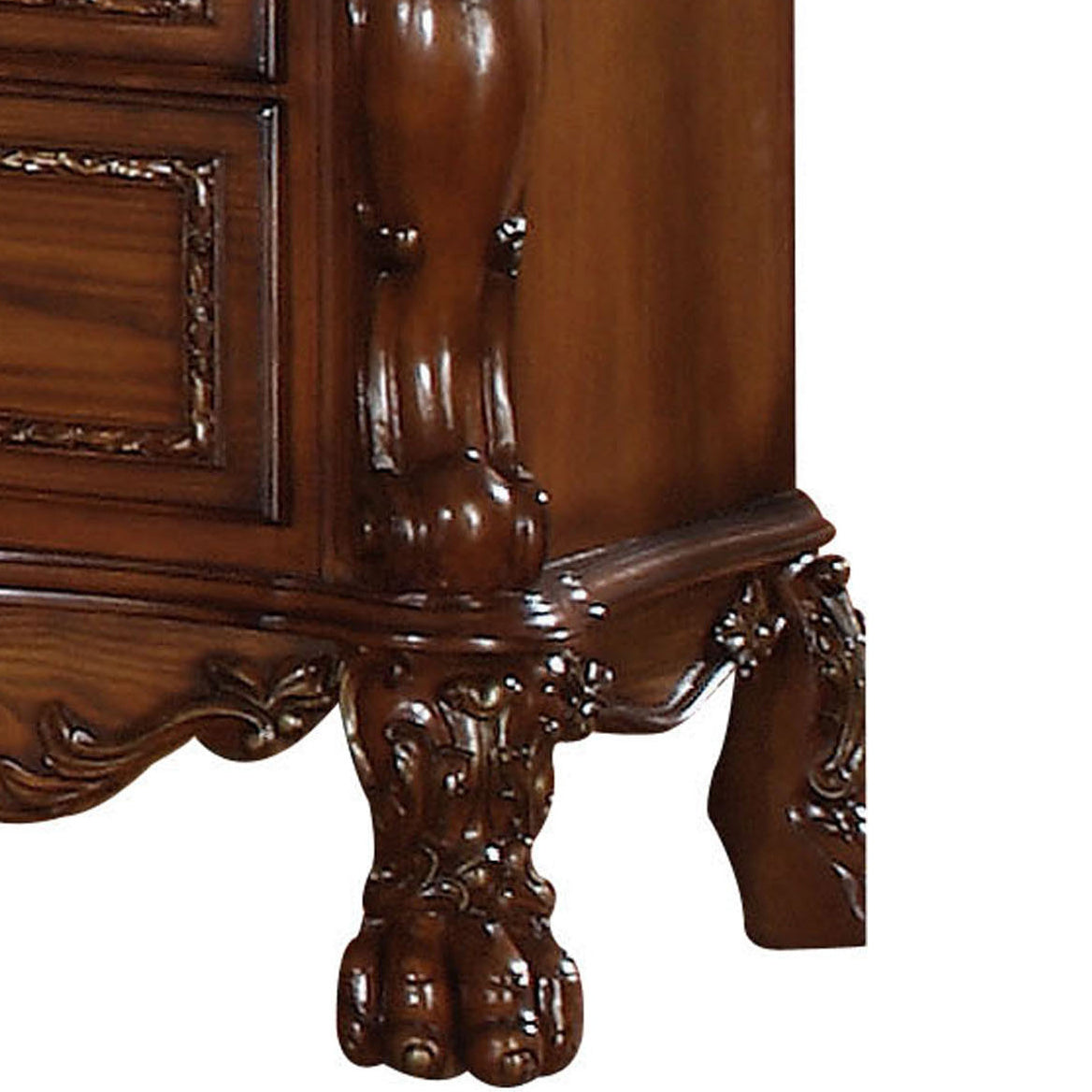Ornate carved wooden furniture leg with claw foot detail on a dark wood dresser