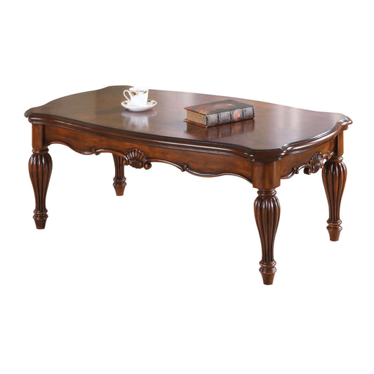 Ornate dark wood coffee table with carved legs and antique book