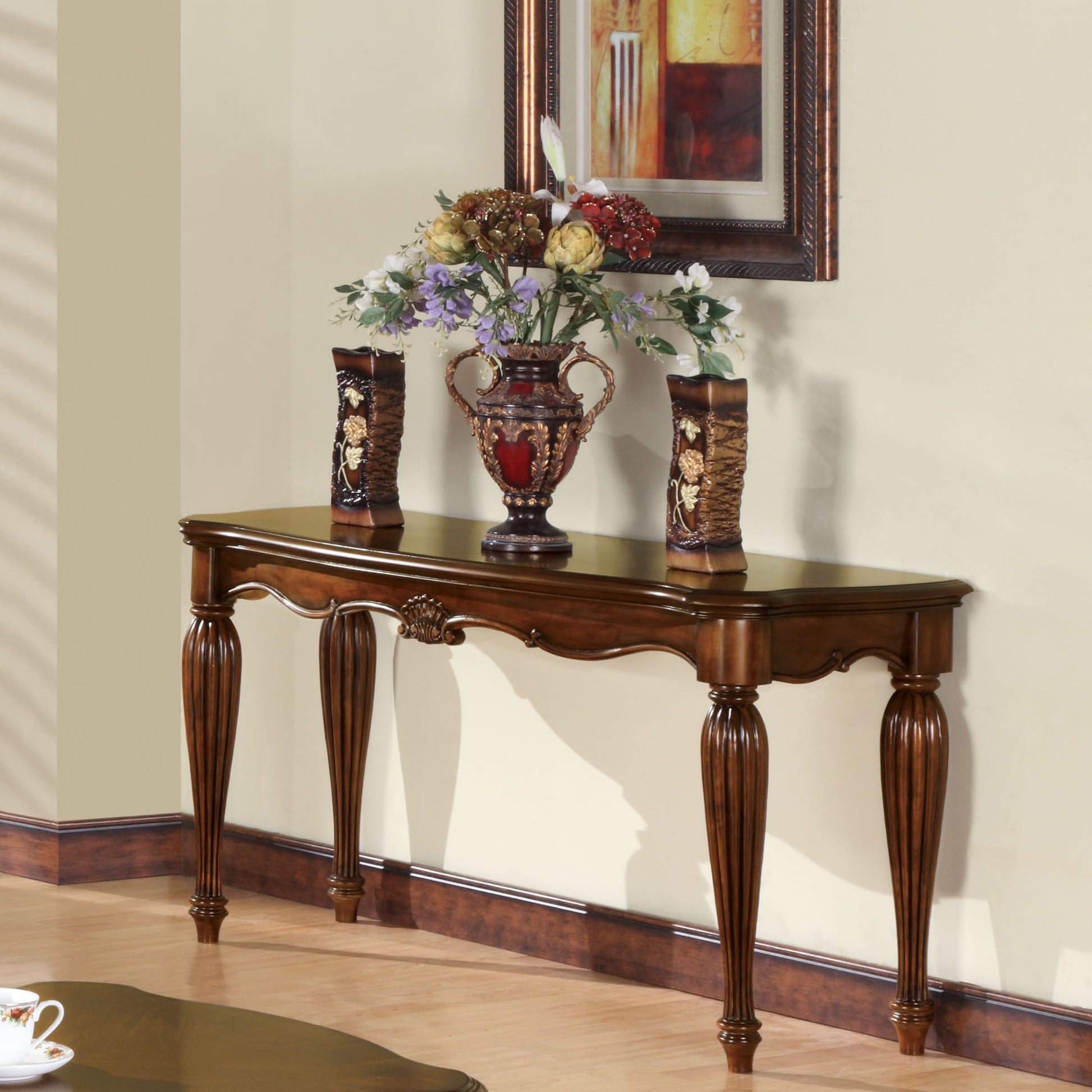 Ornate wooden console table with carved legs and floral art