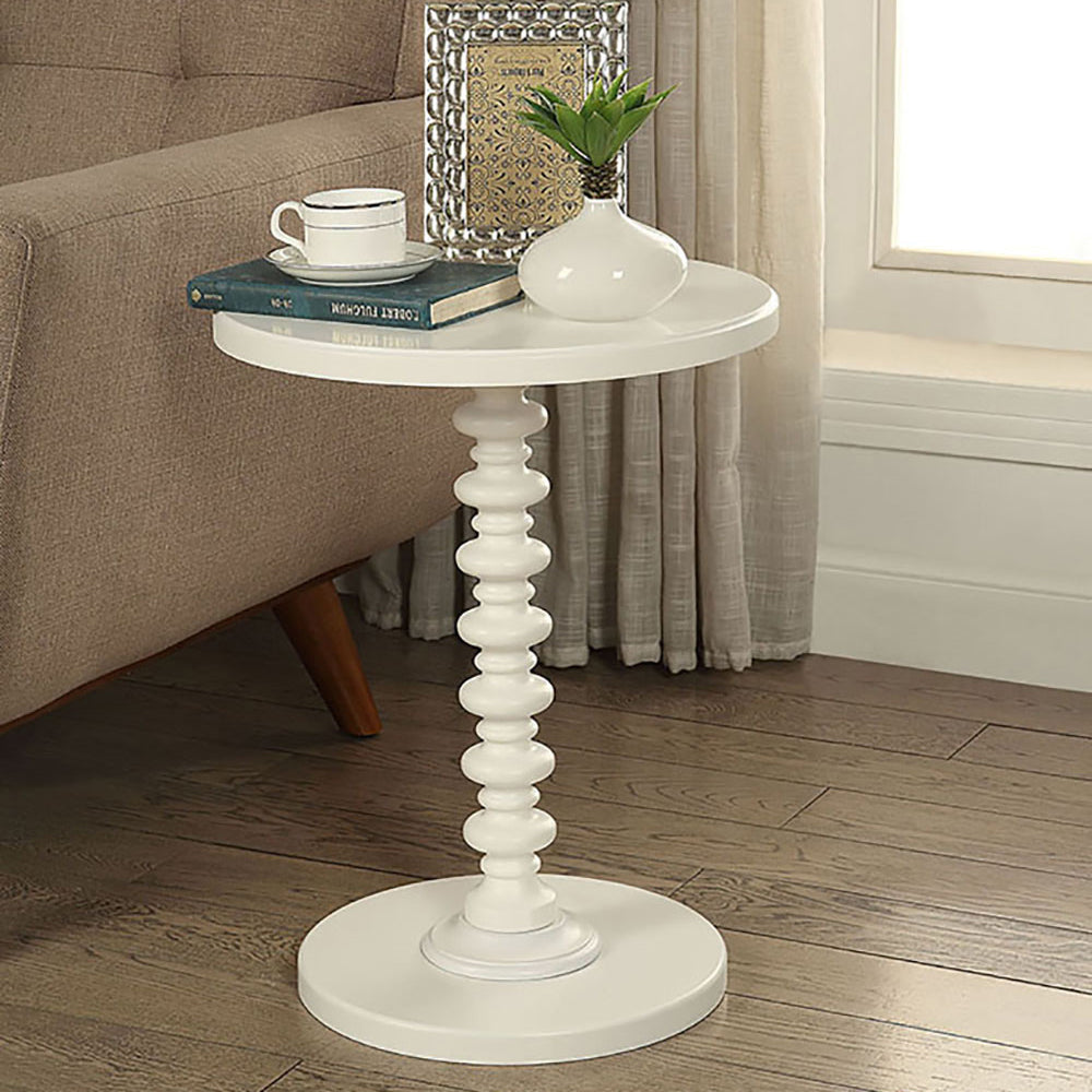 White round accent table with beaded pedestal base and sofa