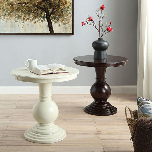 Cream pedestal accent table with open book and mug on top
